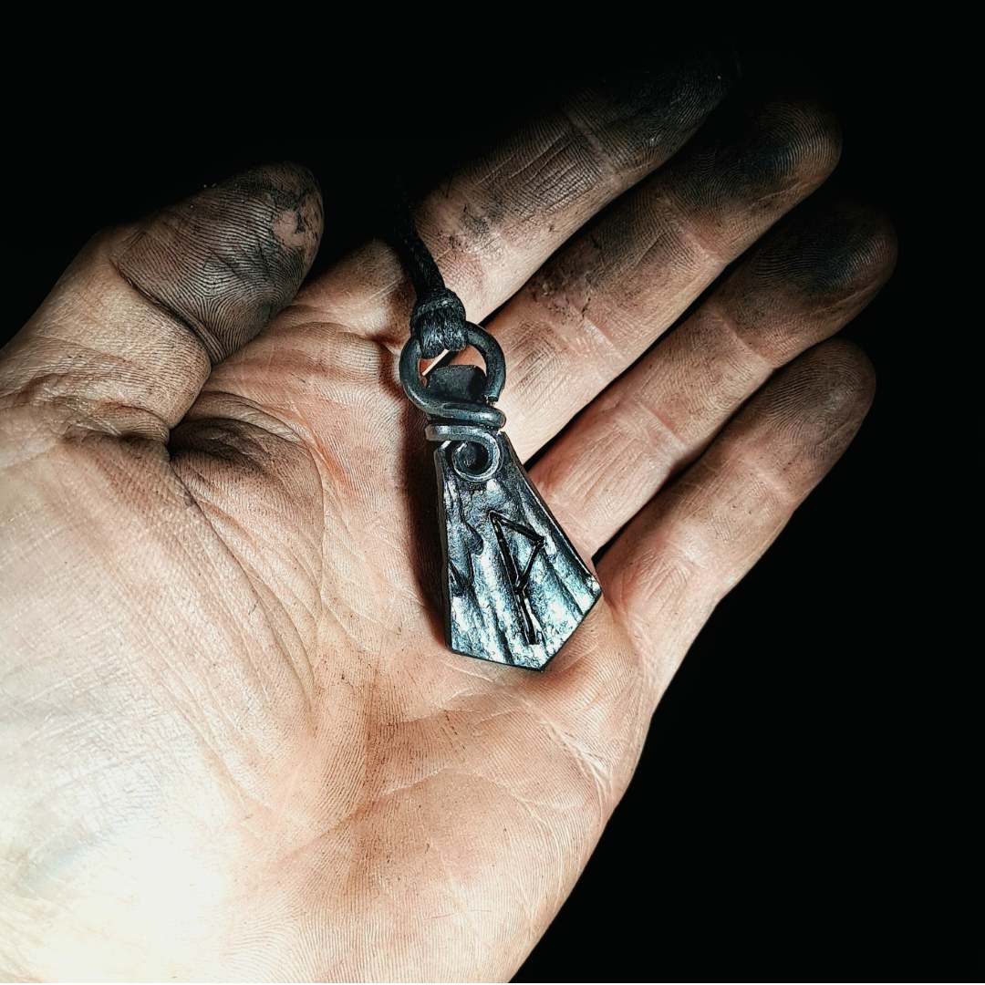 a hand-forged rune pendant in hands
