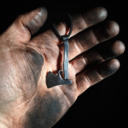 Holding a Hand-forged viking axe pendant 