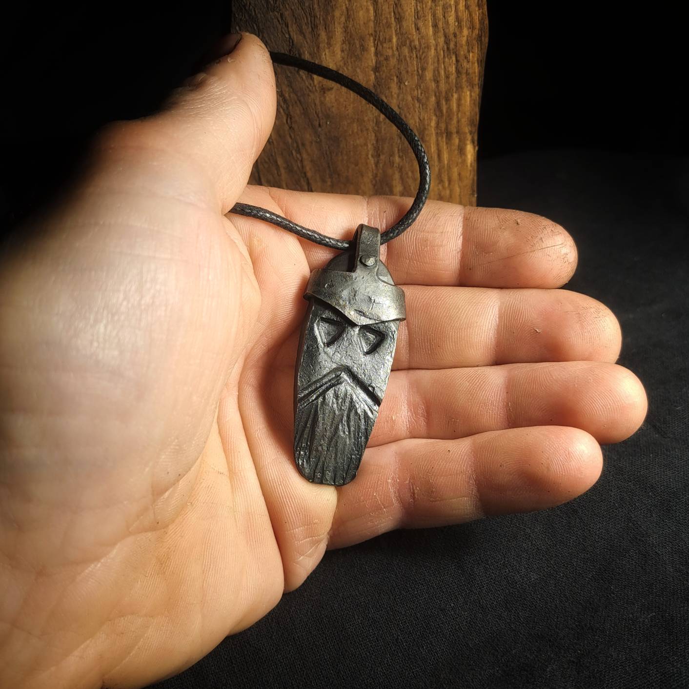 holding a norse god thor pendant