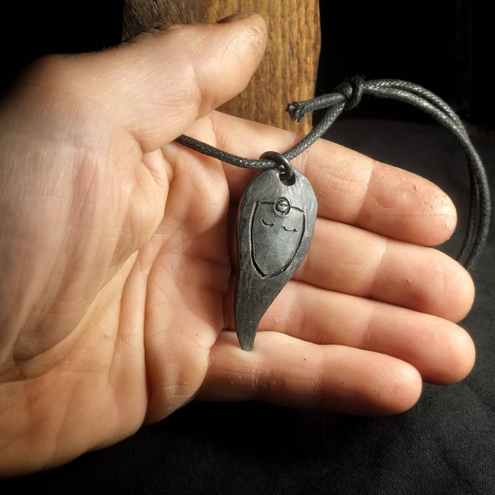 holding a pendant of norse goddess freya