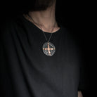 model wearing a sun cross pendant in iron and bronze