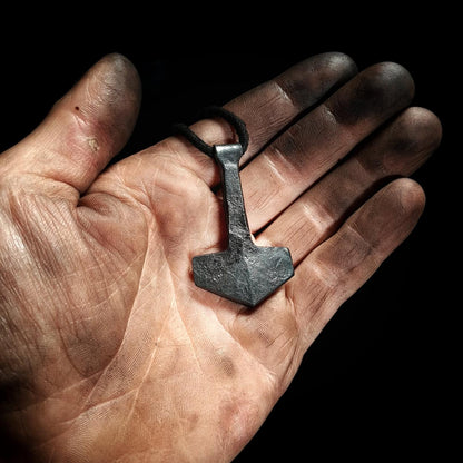 holding thors hammer pendant
