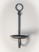 Medieval-inspired blacksmith candle sconce mounted on a white wall.