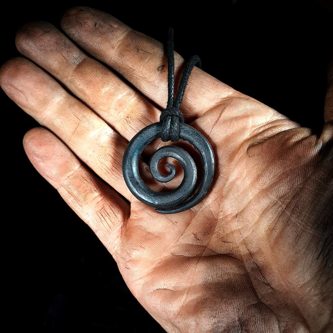 The spiral pendant placed in a hand
