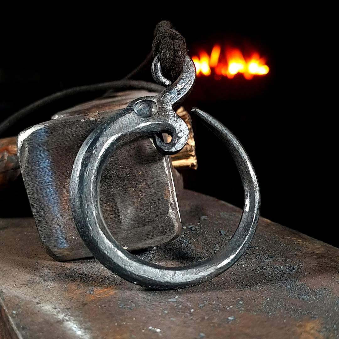 A hand-forged iron Midgard Serpent pendant, depicting the serpent in a traditional style.