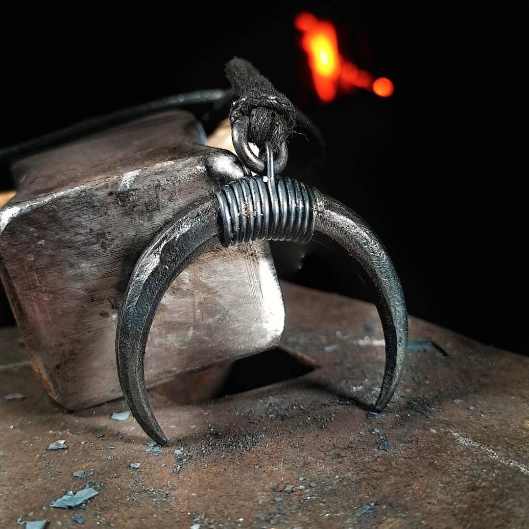 A hand-forged iron moon pendant