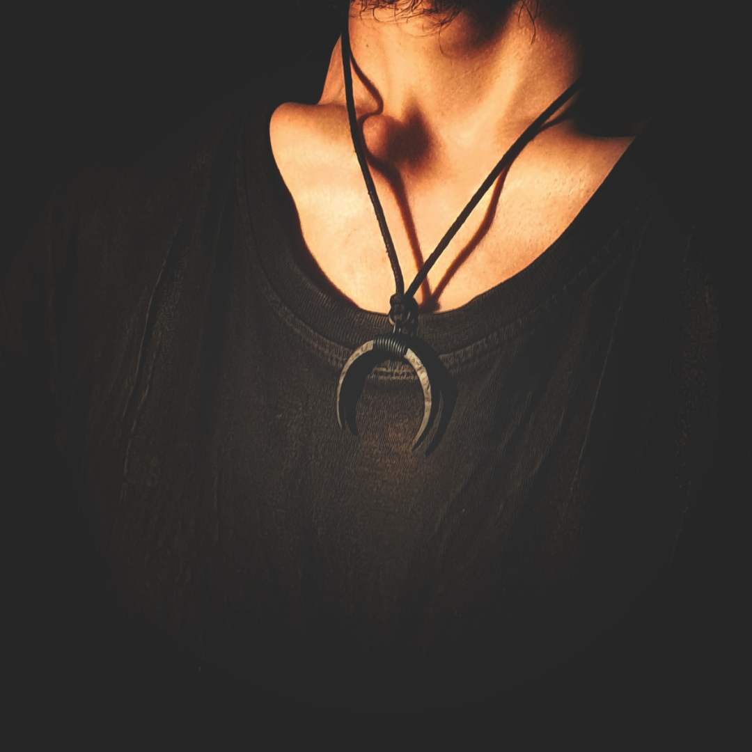 Model wearing a hand-forged iron moon pendant