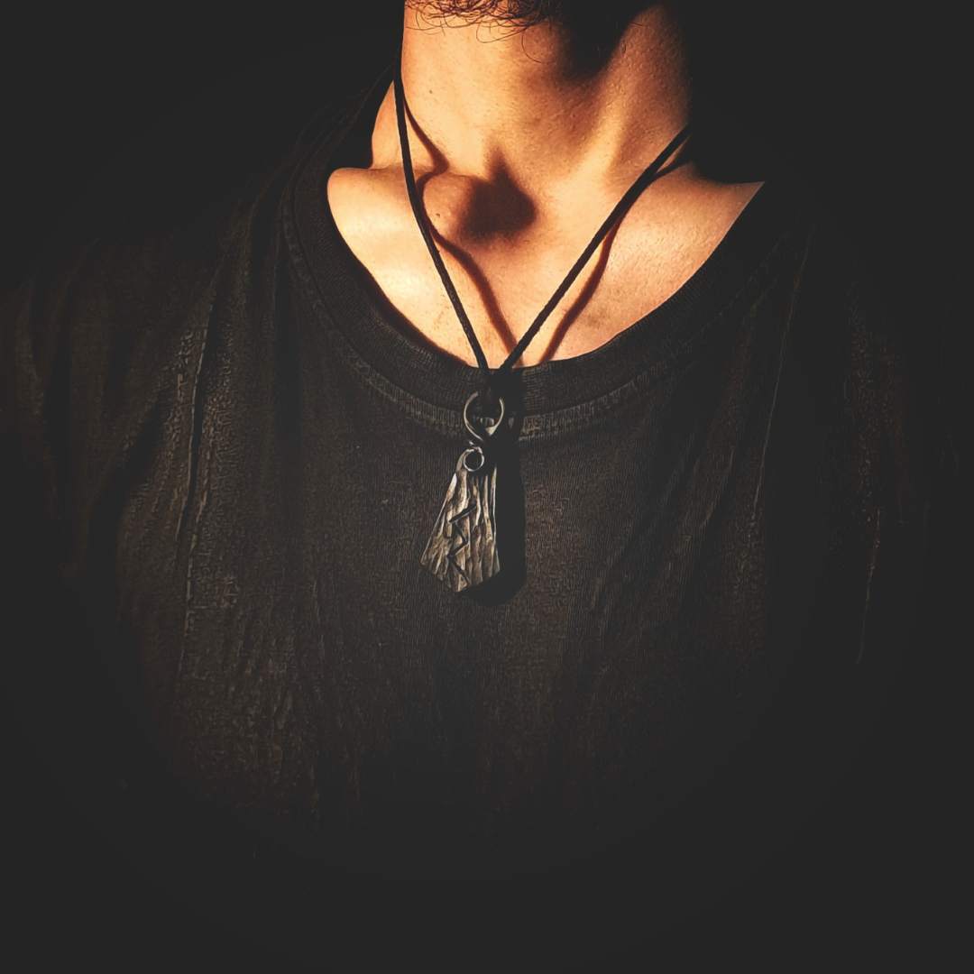 model wearing a hand-forged rune pendant