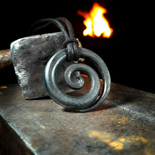A close-up view of a handcrafted spiral pendant, showcasing its intricate details and gleaming iron finish.