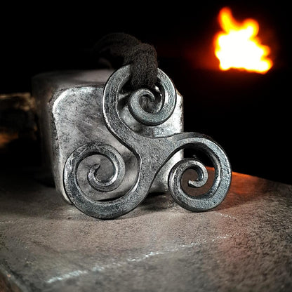 close up on a triskele pendant in iron